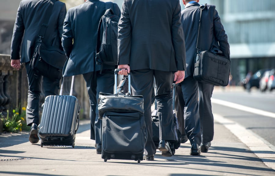 A group of businessmen pulling suitcases with luggage